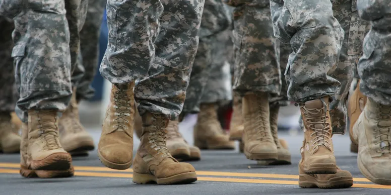 Soldiers marching in camouflage and boots.