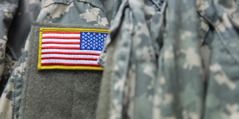 Camouflage uniform with American flag patch.