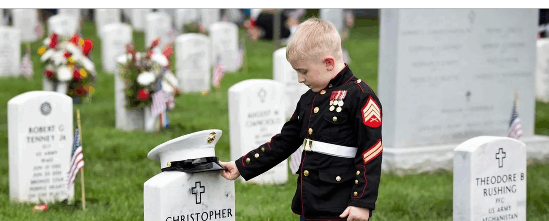 Child in uniform at military cemetery.