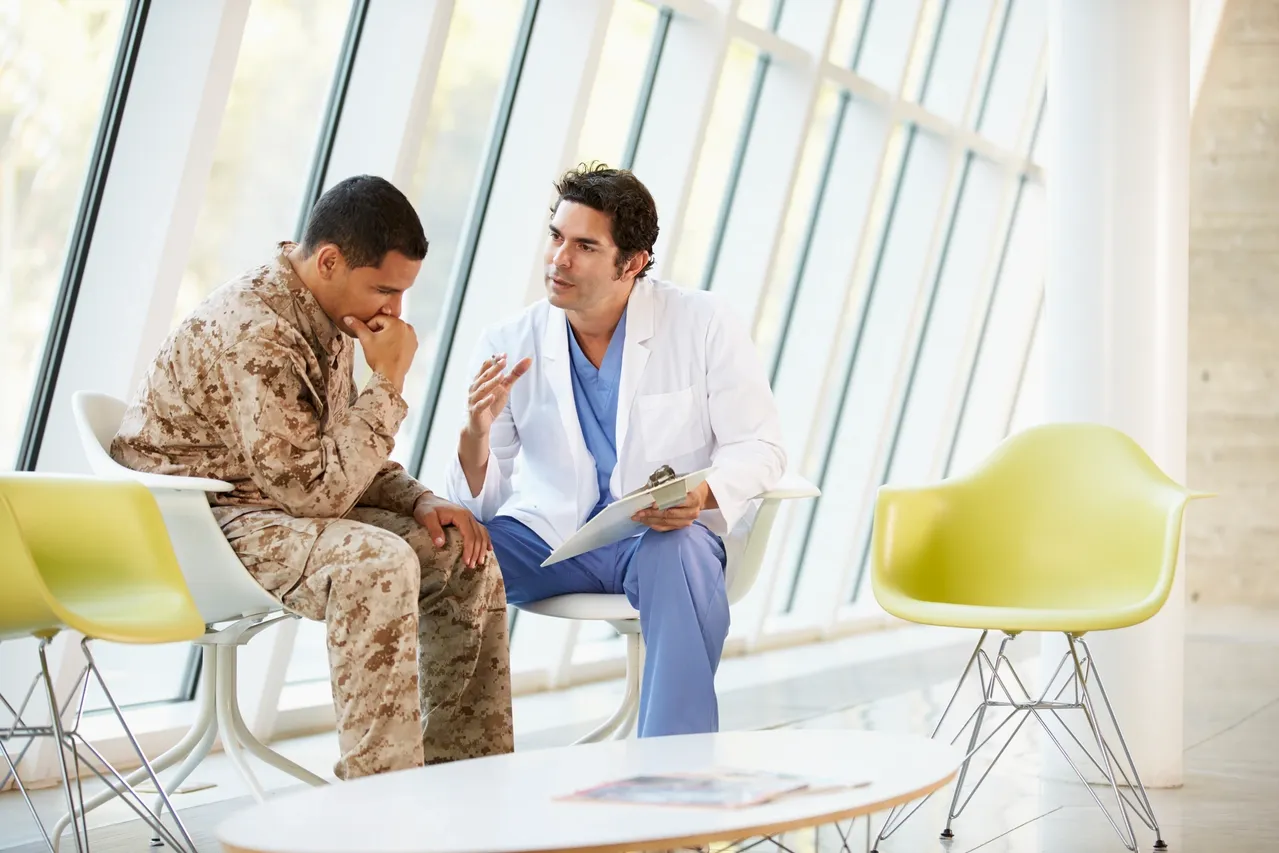 Doctor consulting with a soldier in uniform.