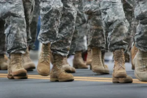 Soldiers marching in camouflage uniforms and boots.