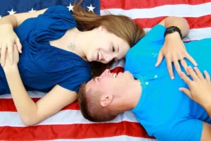 Couple laughing on American flag background.