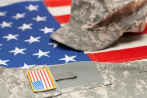 Military uniform and cap on American flag.