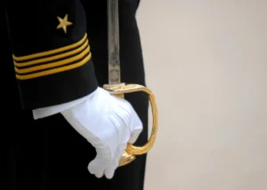 Navy officer holding ceremonial sword.