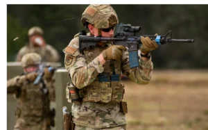 Soldier aiming rifle during training exercise outdoors.