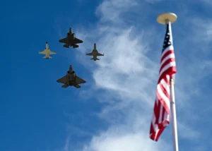 Jets flying over American flag in sky.